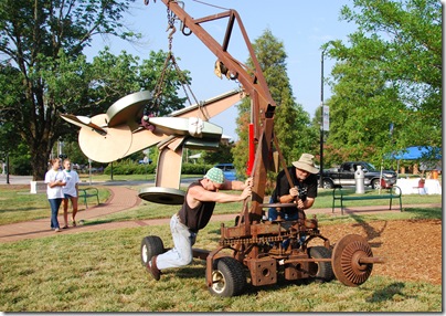 Mike Roig and fellow sculptor Wayne Vaughn move "Air Guitar" into place -photo by Kim Marchesseault