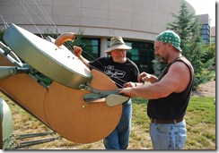 Fellow sculptor Wayne Vaughn assists Mike Roig in stringing  "Air Guitar"